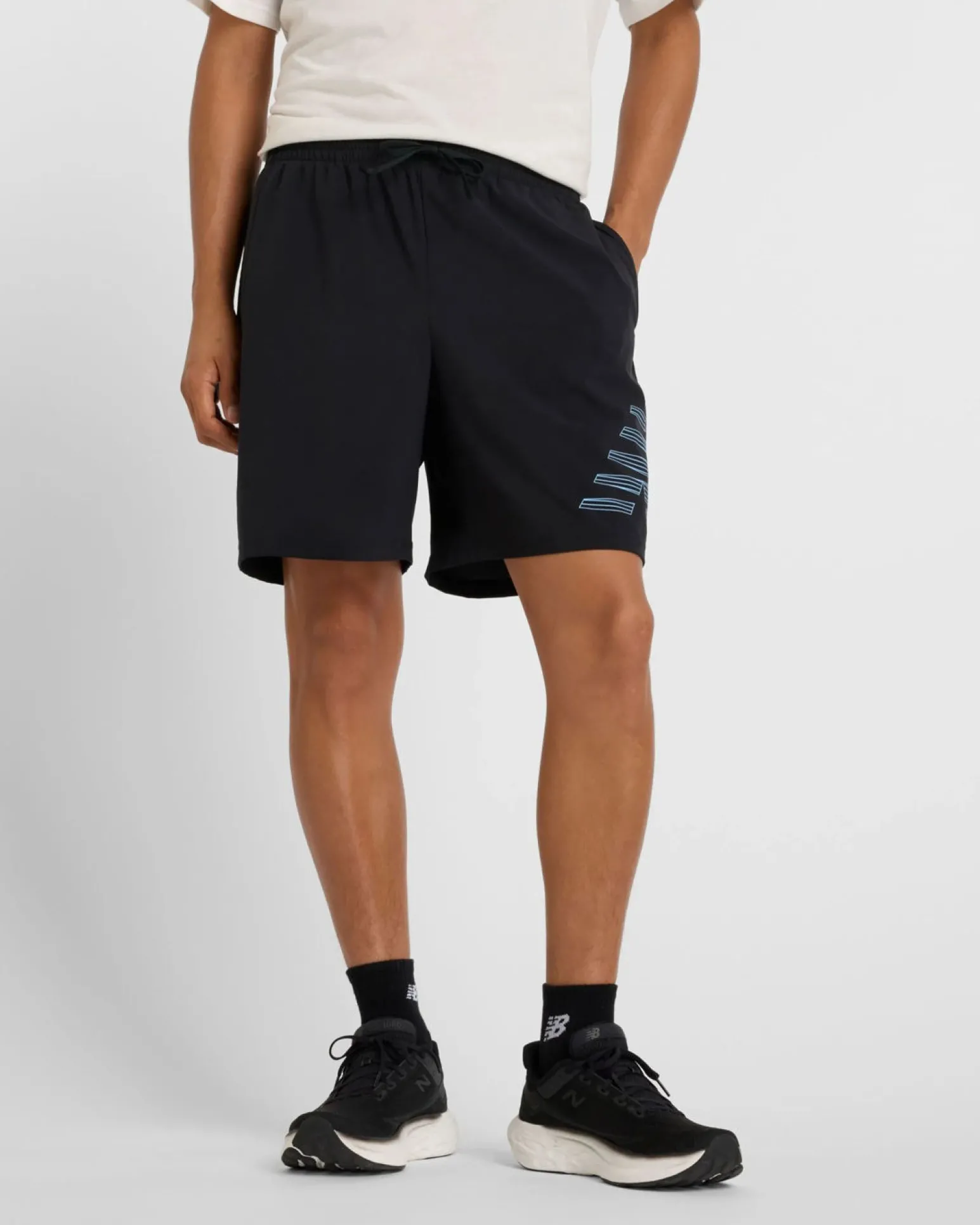 NEW BALANCE - PANTALONCINO UOMO NERO E CELESTE ESSENTIALS LINED GRAPHIC - MS41238BM